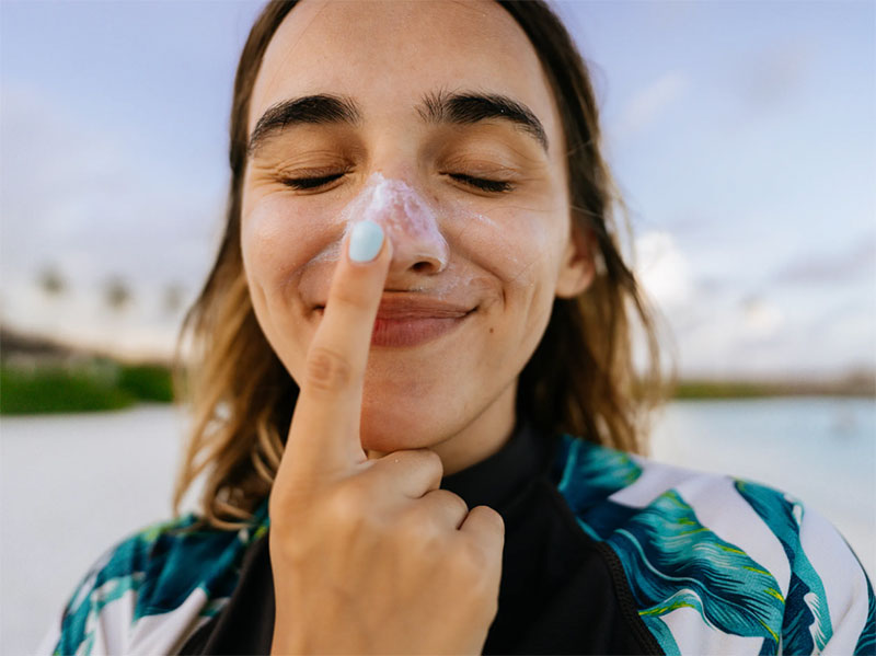 Woman touching nose with sunscreen on it