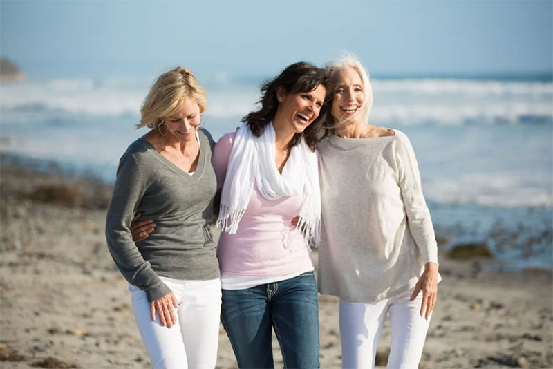 Three women walking together on the beach
